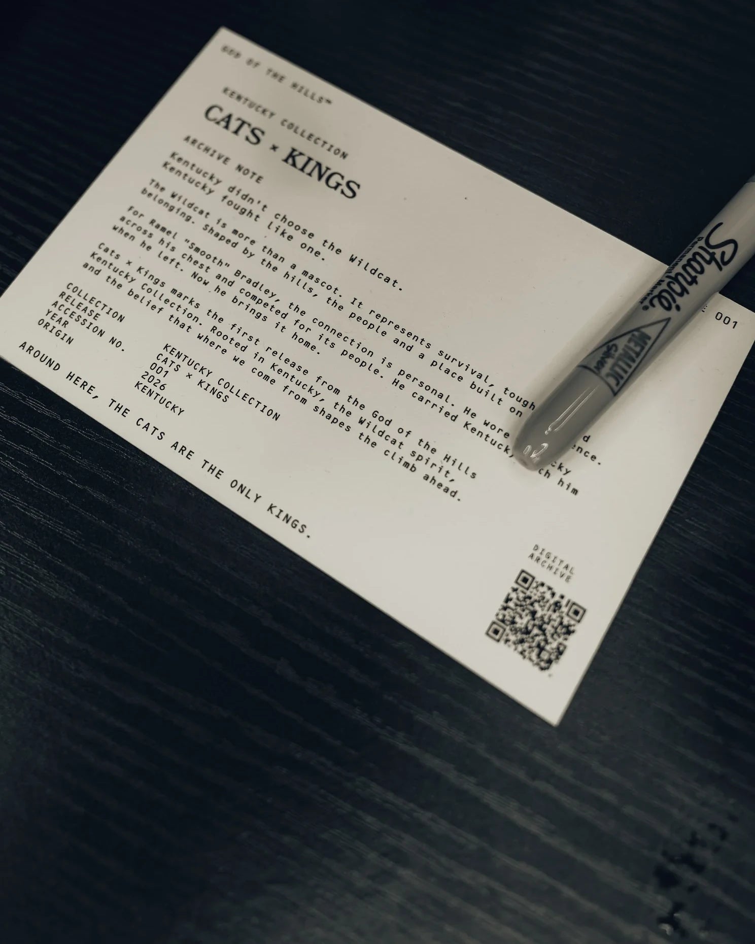 The printed Archive 001 card photographed on the table at Pregame Madness.