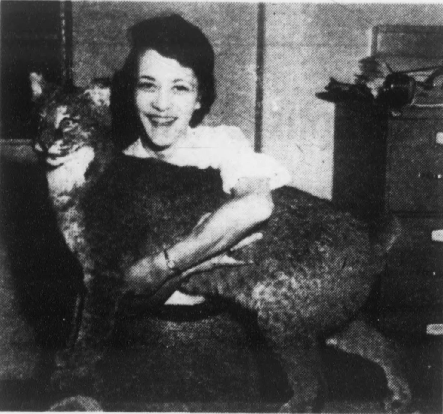 A woman in an office hugs Tucky, the stuffed wildcat mascot, in a 1959 newspaper photograph.